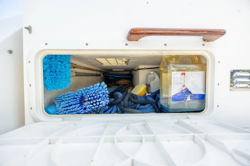 Slide: The Image of Storage compartment of a 1998 Little Harbor WhisperJet 36 with cleaning supplies and ropes. - 44