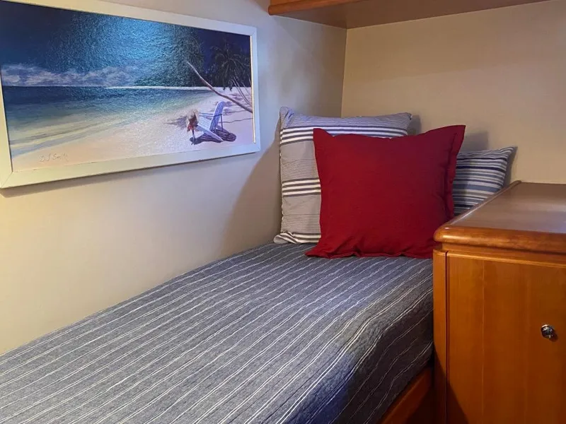 Slide: The Image of Cozy cabin bed in 2003 West Bay 68 yacht with beach artwork and striped bedding. - 21