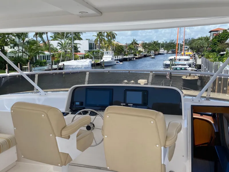 Slide: The Image of Flybridge view of 2003 West Bay 68 yacht overlooking a scenic canal with palm trees. - 24