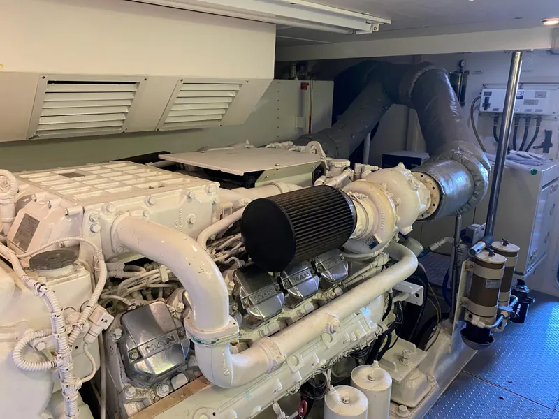Slide: The Image of Engine room of a 2003 West Bay 68 yacht, featuring a large marine engine. - 27