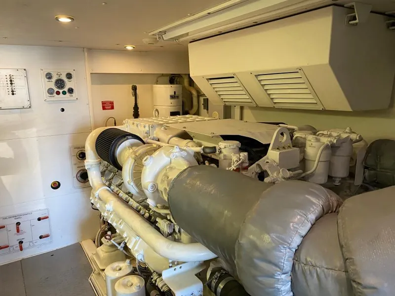 Slide: The Image of Engine room of 2003 West Bay 68 yacht, featuring mechanical components and control panels. - 28