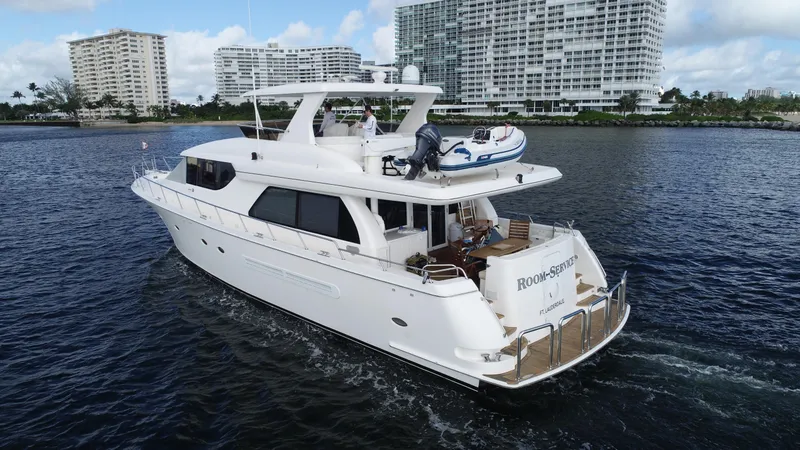 Slide: The Image of Luxury 2003 West Bay 68 yacht cruising near coastal high-rise buildings. - 3