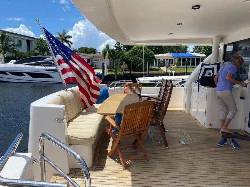 Slide: The Image of Outdoor deck of 2003 West Bay 68 yacht with seating, table, and American flag. - 6