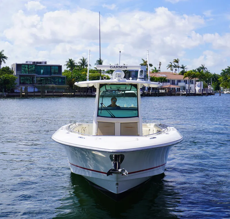 Slide: The Image of 2020 Boston Whaler 350 Outrage boat on water with waterfront homes in background. - 4