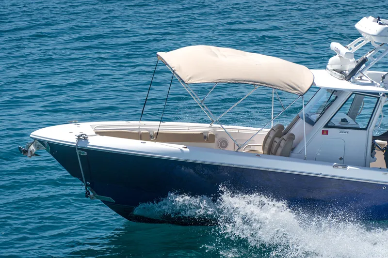 Slide: The Image of 2019 Everglades 355 Center Console boat cruising on blue ocean water. - 14