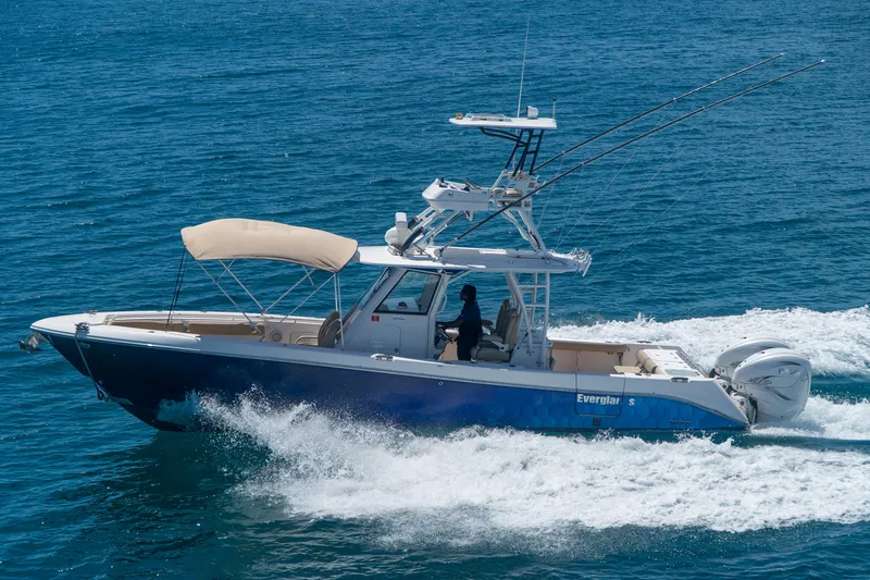 Slide: The Image of 2019 Everglades 355 Center Console boat cruising on blue ocean water. - 2
