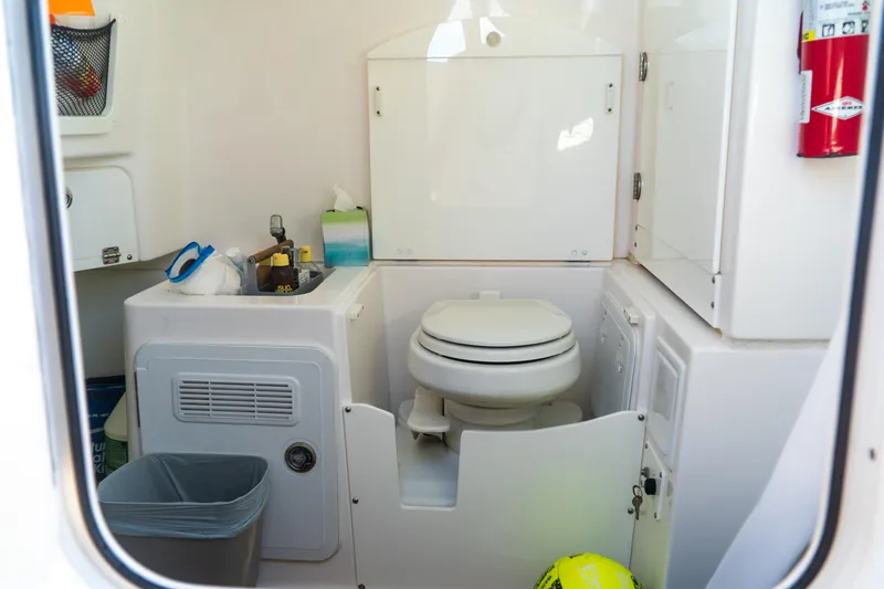 Slide: The Image of 2019 Everglades 355 Center Console boat bathroom with toilet and sink. - 9
