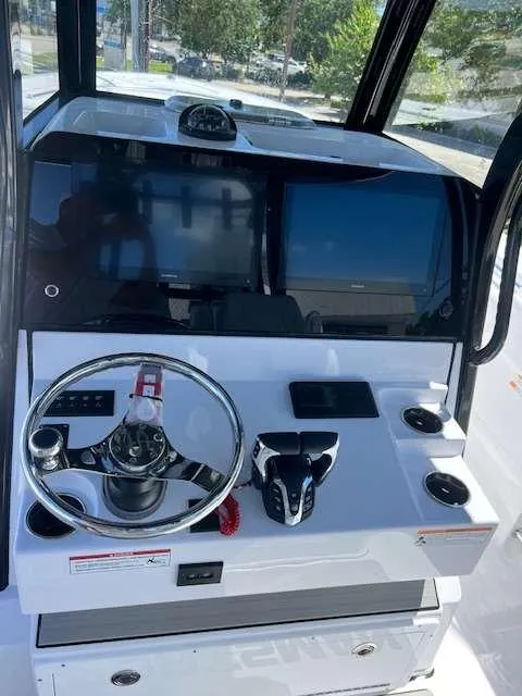 Slide: The Image of 2025 Sportsman 282 Open boat dashboard with steering wheel and electronic displays. - 3
