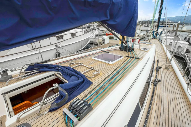 Slide: The Image of Nautor Swan 48 (2001) sailboat deck with blue cover, docked at marina. - 19