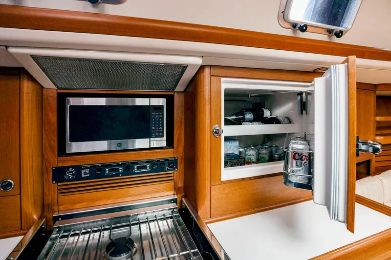 Slide: The Image of Nautor Swan 48 (2001) yacht kitchen with microwave, stove, and open fridge. - 36