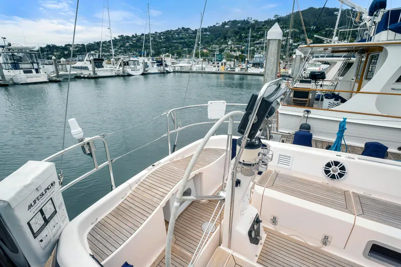 Slide: The Image of Nautor Swan 48 sailboat, 2001 model, docked at a marina with scenic hillside view. - 7