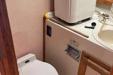 Slide: The Image of 1986 Silverton 37 Convertible boat bathroom with toilet and sink area. - 13