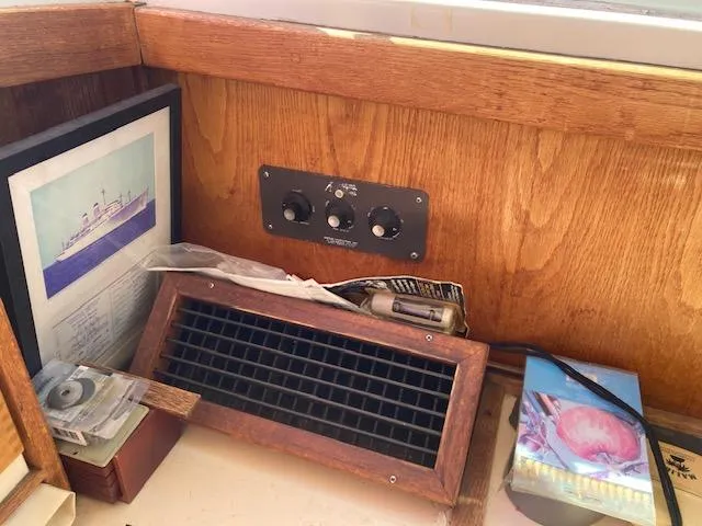 Slide: The Image of 1986 Silverton 37 Convertible interior with wooden panel, framed picture, and control knobs. - 14