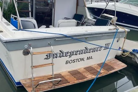 Slide: The Image of 1986 Silverton 37 Convertible boat named "Independence III" docked in Boston, MA. - 2