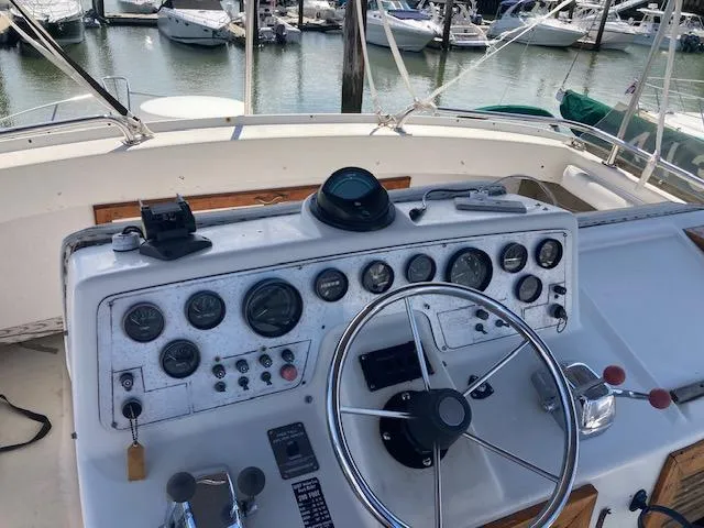 Slide: The Image of 1986 Silverton 37 Convertible boat helm with gauges and steering wheel at marina. - 3