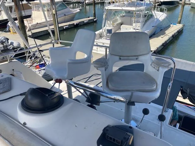 Slide: The Image of 1986 Silverton 37 Convertible boat with white captain chairs at marina. - 4