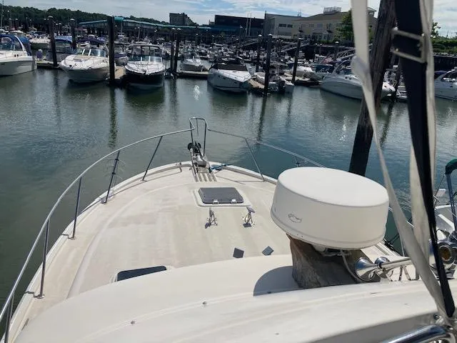 Slide: The Image of 1986 Silverton 37 Convertible yacht docked in a marina, surrounded by other boats. - 5