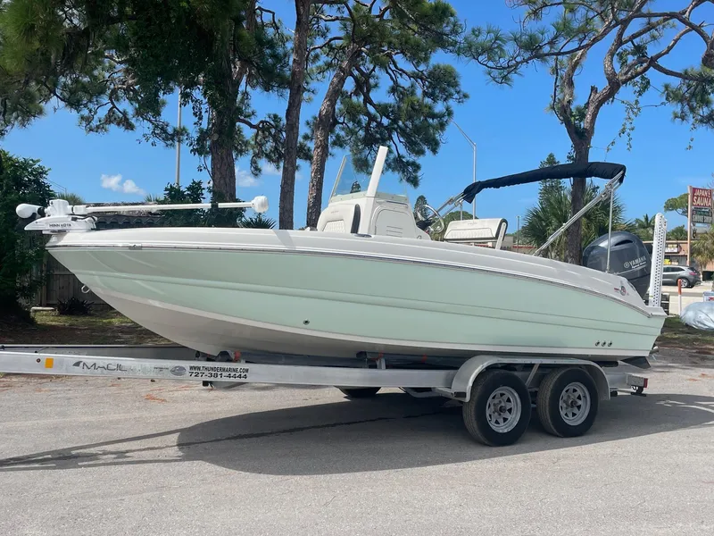 Slide: The Image of 2020 Stingray 206 CC boat on a trailer with trees in the background. - 0