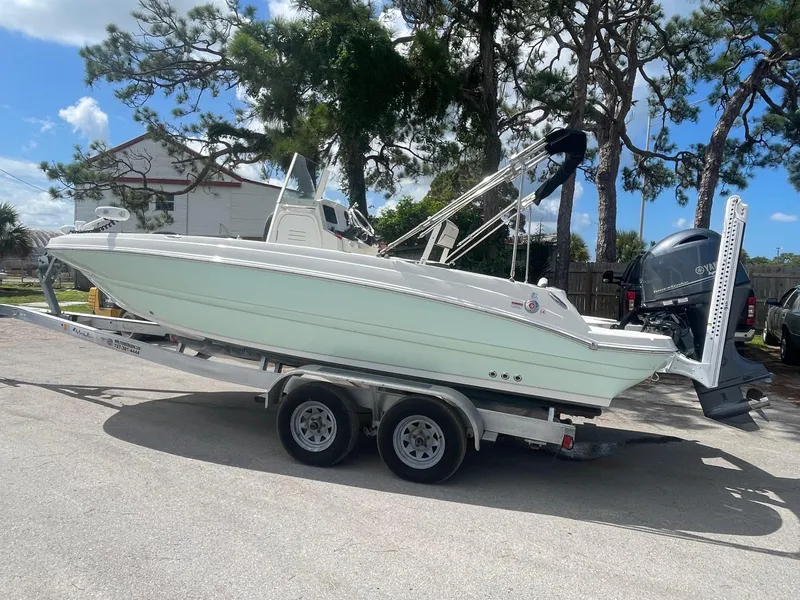 Slide: The Image of 2020 Stingray 206 CC boat on a trailer in a sunny outdoor setting. - 2