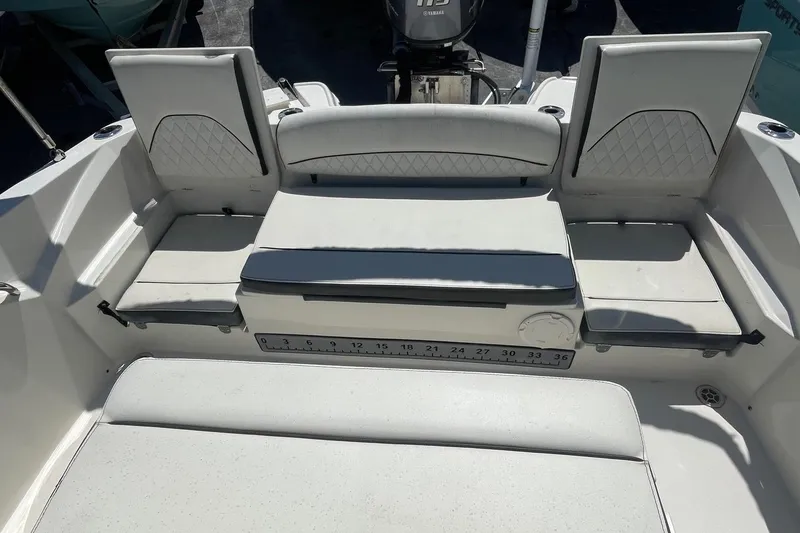 Slide: The Image of 2020 Stingray 206 CC boat interior with cushioned seating and outboard motor. - 7