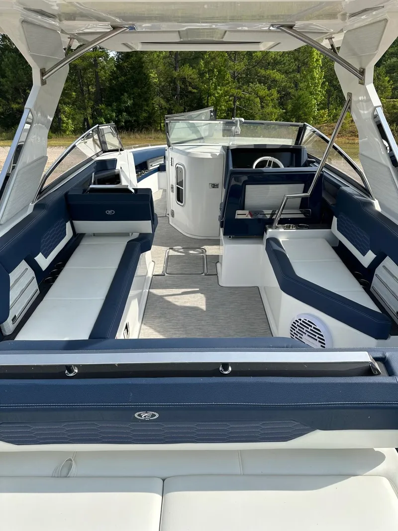 Slide: The Image of 2022 Cobalt A29 boat interior with blue and white seating, open deck, and steering console. - 6