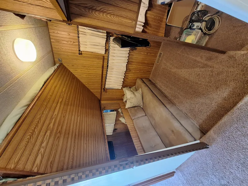 Slide: The Image of 1986 Skipperliner houseboat interior with wood paneling and beige sofa. - 12