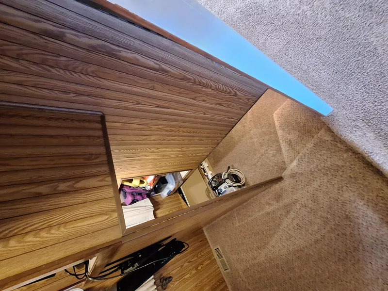 Slide: The Image of Interior of a 1986 Skipperliner houseboat with wood paneling and carpeted flooring. - 13