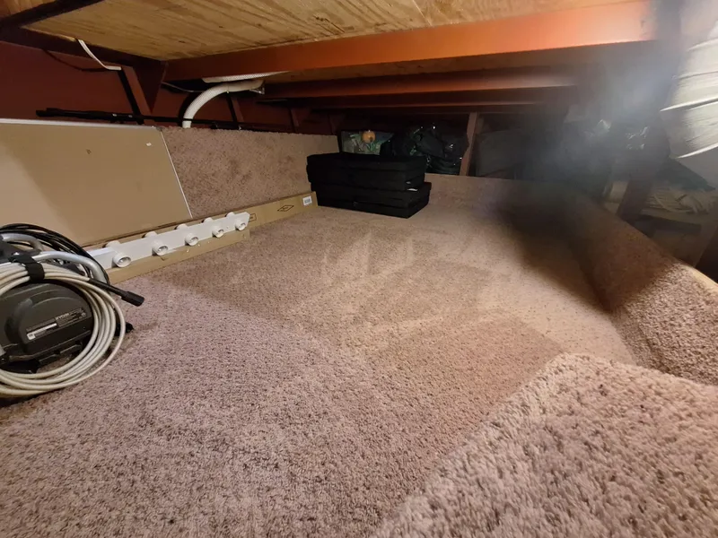 Slide: The Image of 1986 Skipperliner Houseboat interior storage area with carpeted flooring and various equipment. - 15