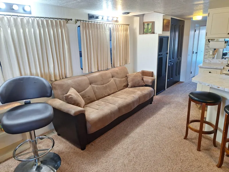 Slide: The Image of Interior of a 1986 Skipperliner houseboat with beige sofa and bar stools. - 19