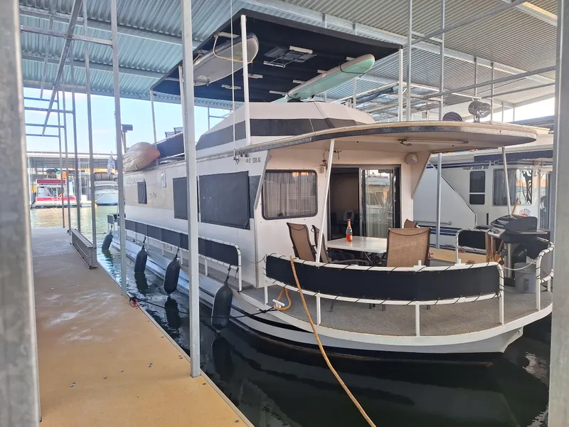 Slide: The Image of 1986 Skipperliner houseboat docked in a covered marina. - 2