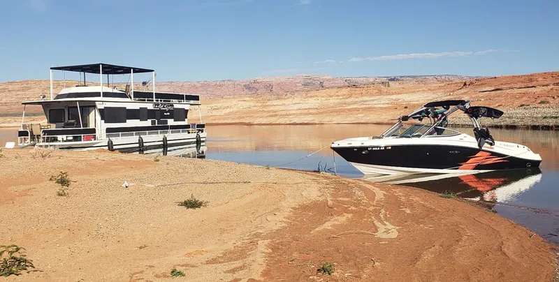 Slide: The Image of 1986 Skipperliner houseboat and speedboat on a sandy shore with desert landscape. - 25