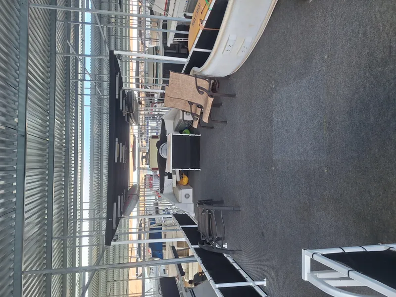 Slide: The Image of 1986 Skipperliner houseboat interior with seating and storage under a covered dock. - 26