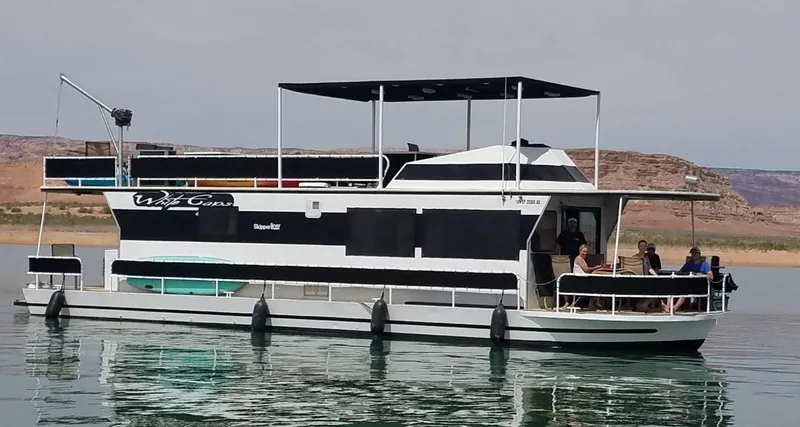 Slide: The Image of 1986 Skipperliner houseboat on a calm lake with people on deck. - 3