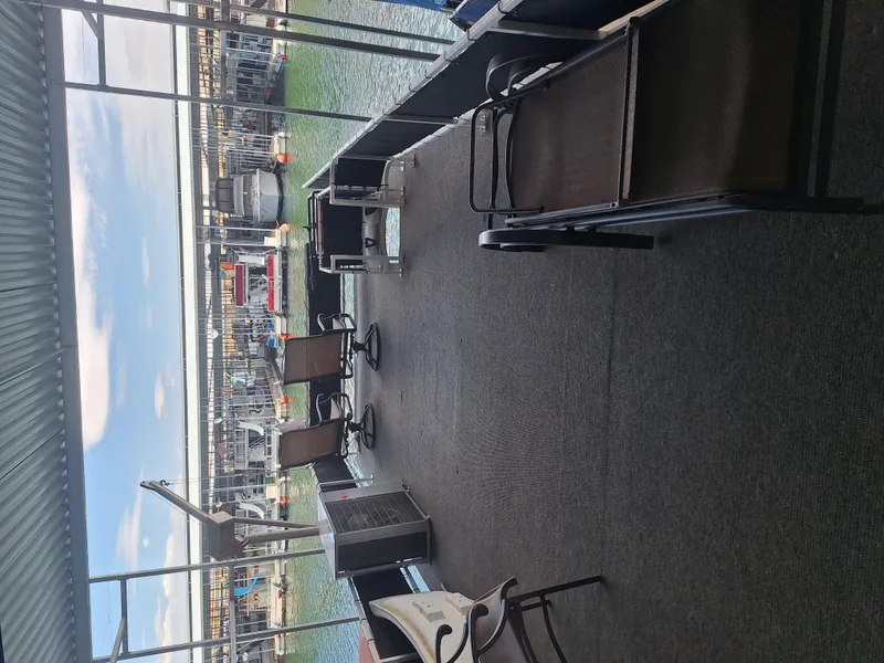 Slide: The Image of 1986 Skipperliner houseboat deck with chairs, overlooking marina and water. - 5