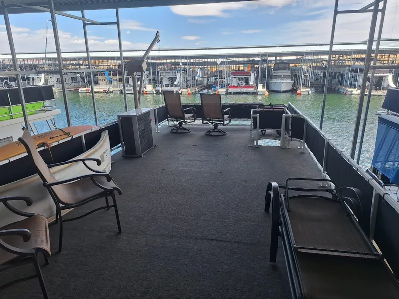 Slide: The Image of 1986 Skipperliner Houseboat deck with seating, docked at a marina. - 6