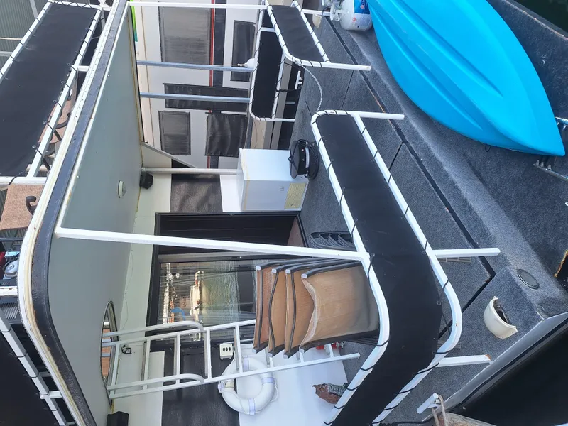 Slide: The Image of 1986 Skipperliner houseboat deck with seating and blue kayak. - 7