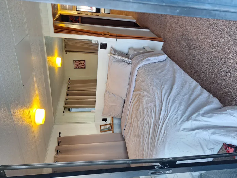 Slide: The Image of Interior of a 1986 Skipperliner houseboat bedroom with cozy bed and warm lighting. - 8