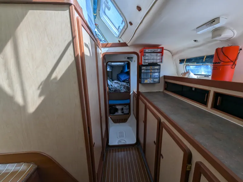 Slide: The Image of Interior of 1998 Shuttleworth Ocean Cheetah 37 catamaran, featuring wood paneling and storage compartments. - 28