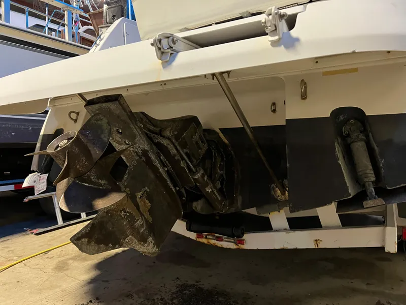 Slide: The Image of 1997 Four Winns 258 Vista boat stern with propeller and outdrive in a workshop. - 11