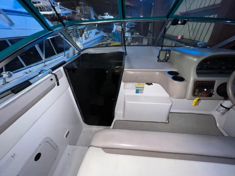 Slide: The Image of 1997 Four Winns 258 Vista boat cockpit with steering wheel and navigation equipment. - 15