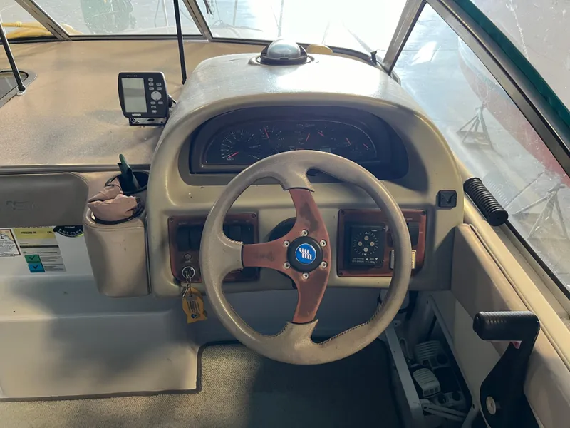 Slide: The Image of 1997 Four Winns 258 Vista boat helm with steering wheel and instrument panel. - 19