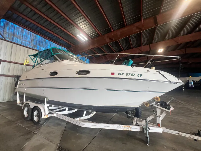 Slide: The Image of 1997 Four Winns 258 Vista boat on a trailer in a storage facility. - 2