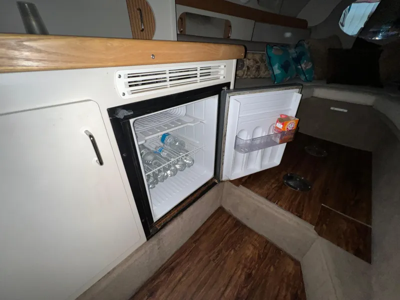 Slide: The Image of 1997 Four Winns 258 Vista cabin interior with open mini fridge. - 27