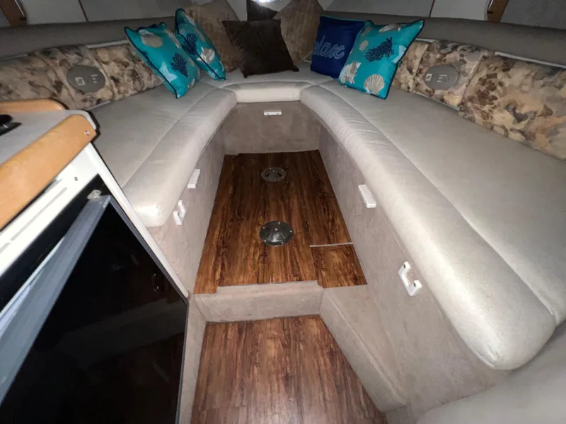 Slide: The Image of 1997 Four Winns 258 Vista cabin interior with cushioned seating and decorative pillows. - 28