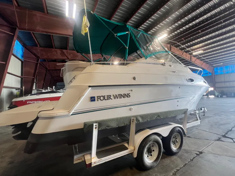 Slide: The Image of 1997 Four Winns 258 Vista boat on a trailer in a storage facility. - 3