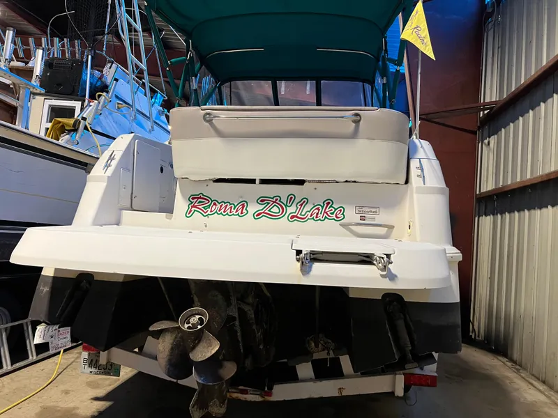 Slide: The Image of 1997 Four Winns 258 Vista boat in storage, rear view with green canopy. - 5