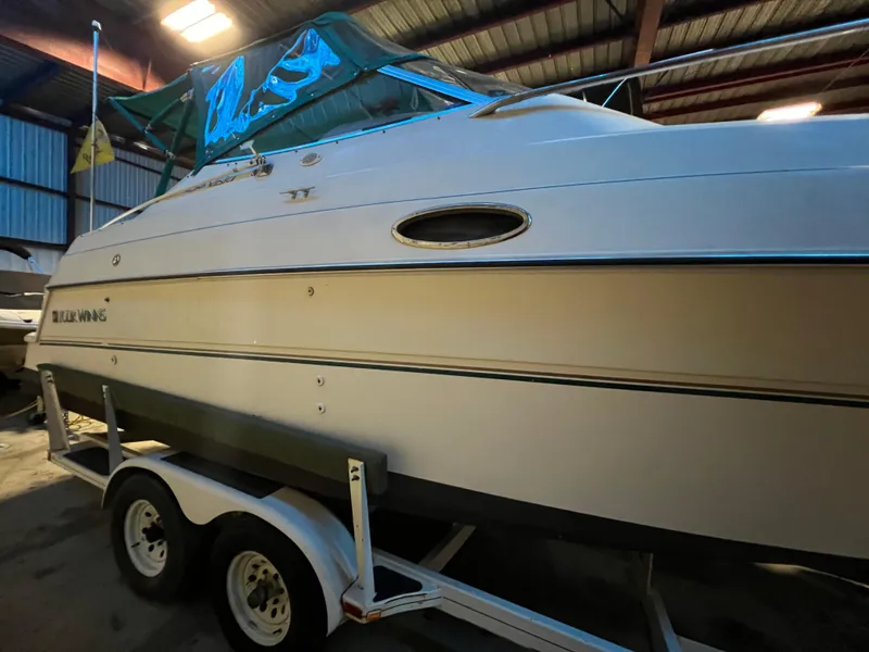 Slide: The Image of 1997 Four Winns 258 Vista boat on a trailer in a storage facility. - 8