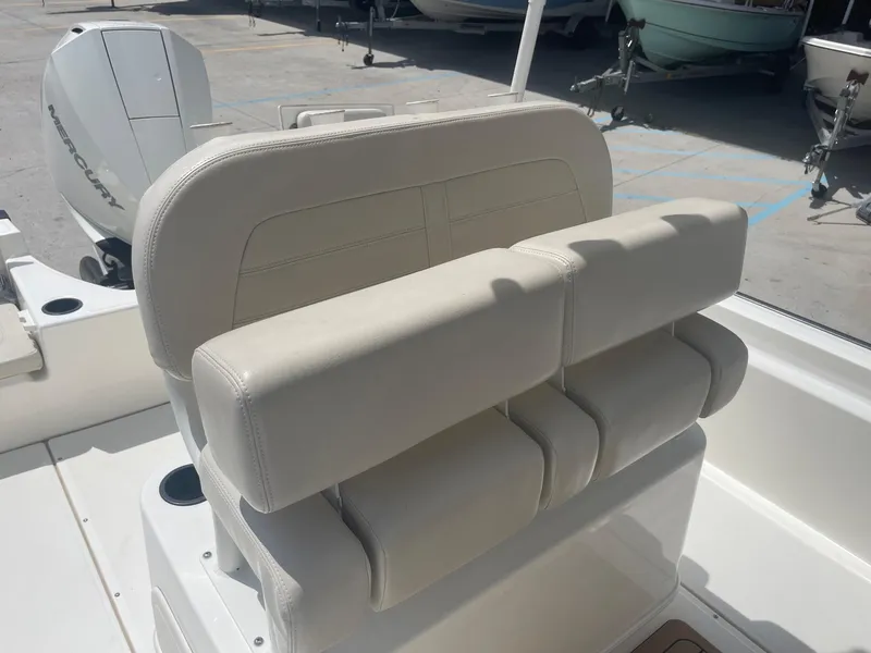 Slide: The Image of 2019 Boston Whaler 210 Montauk boat with white cushioned seating and Mercury outboard motor. - 16