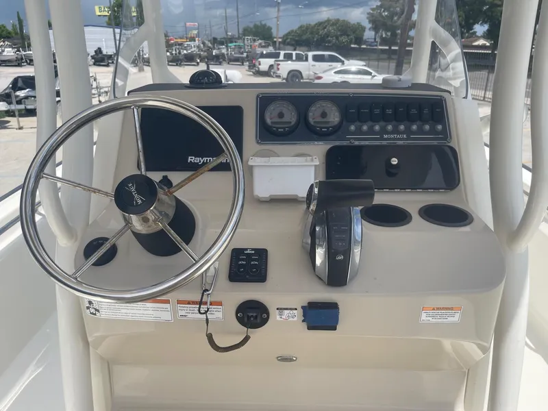 Slide: The Image of 2019 Boston Whaler 210 Montauk boat console with steering wheel and navigation instruments. - 18