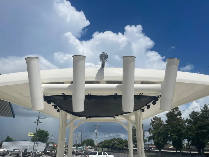 Slide: The Image of 2019 Boston Whaler 210 Montauk boat with rod holders and T-top under a blue sky. - 22
